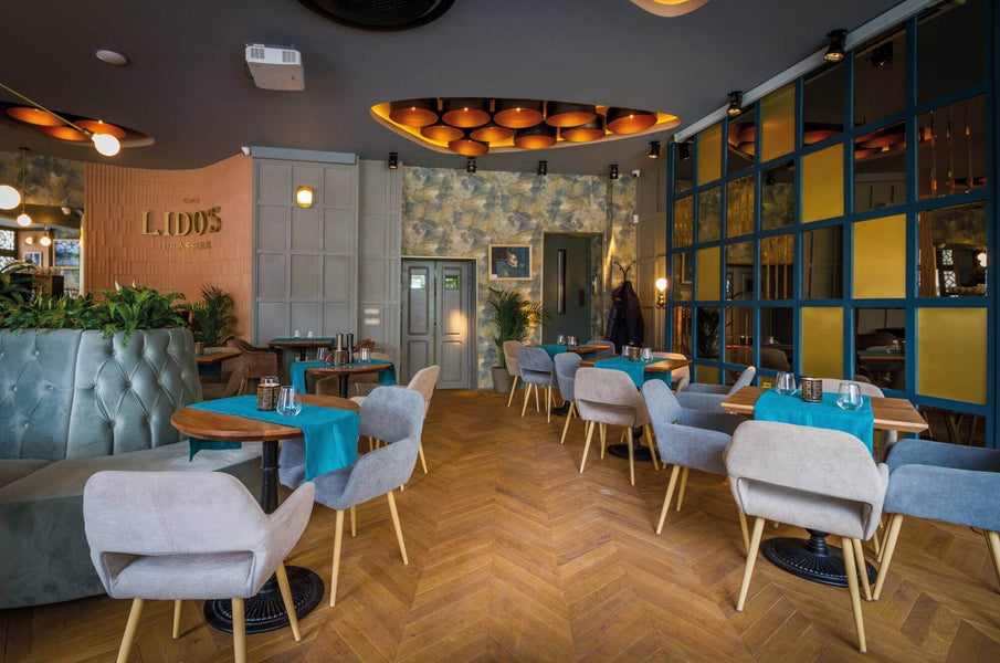 Trendy restaurant with hardwood flooring in chevron pattern.