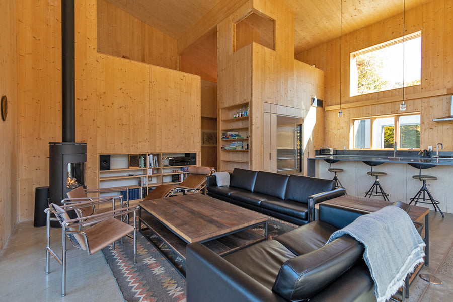 Contemporary lodge living room with wood stove. White oak coffee table and side tables are finished with Oil Plus 2C Pure, a hardwax oil by Rubio Monocoat.