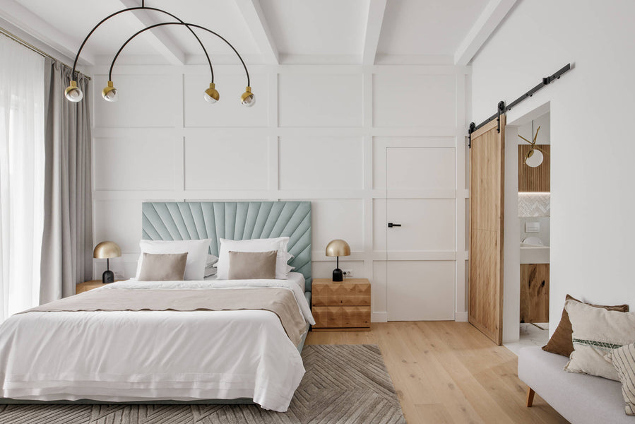 A master bedroom with light colored hardwood floors, a white oak side table finished with hardwax oil and a upholstered bed frame.