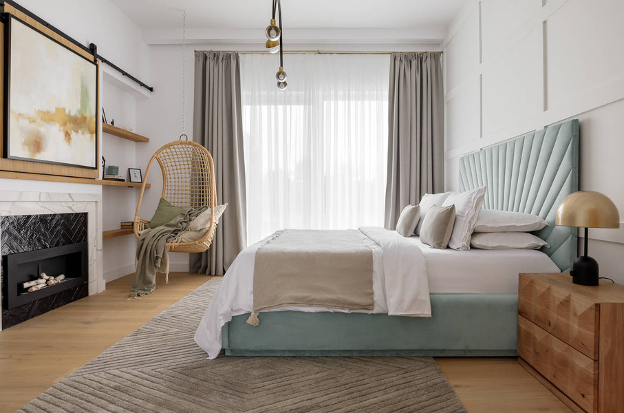Side view of the blue fabric upholstered master bed. Also shown is a geometric inspired white oak side table finished with Rubio Monocoat Oil Plus 2C.