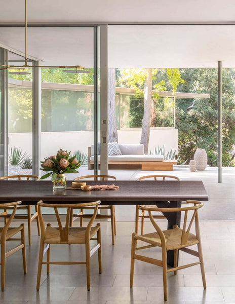 Dining area in the Oakdell Residence featuring a large dining table and wishbone dining chairs.