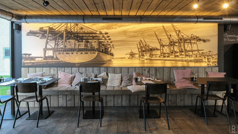 Inside of shipping container pop-up restaurant with wood paneling inside.