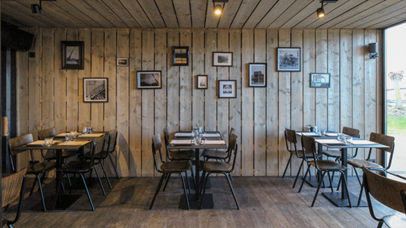 Tables inside of a shipping container pop-up restaurant.