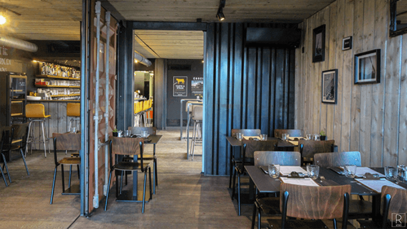 A pop-up restaurant made from shipping containers containers tables, decor, and wood flooring finished with Rubio Monocoat hardwax oil wood finishes.
