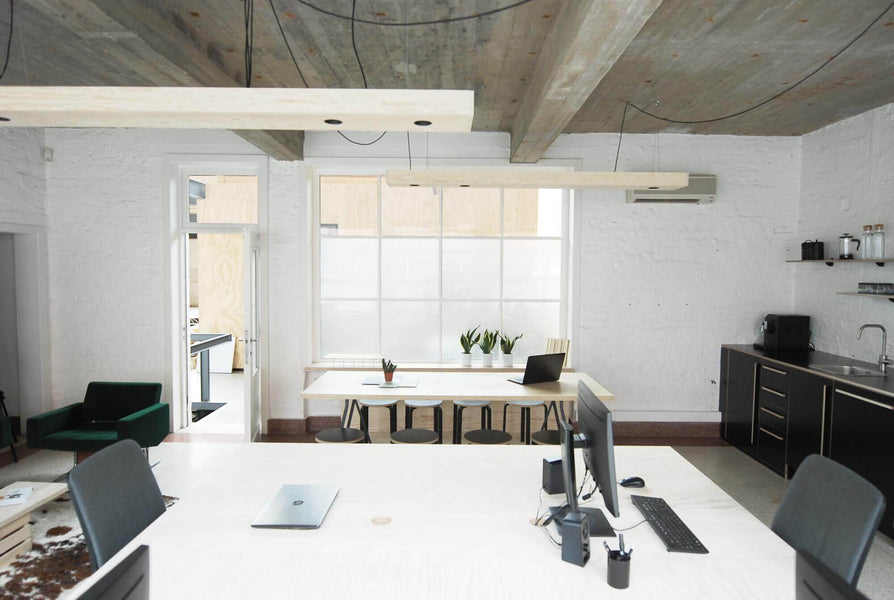 Architectural offices with white bricks, grey ceiling, and light plywood accents.