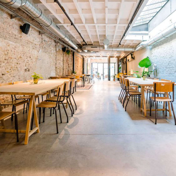 Several tables and chairs sit in an eating area at this Belgian event space. The wooden elements are finished with Rubio Monocoat Oil Plus 2C.