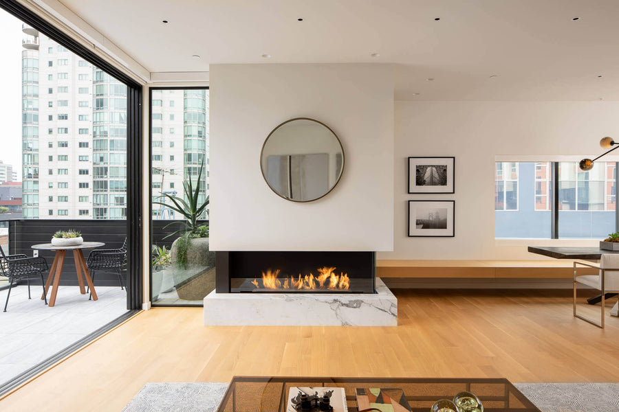 Living room with fireplace and floor to ceiling glass doors that are open, rift sawn white oak flooring.