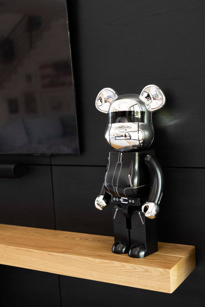 An up close images of a mickey mouse figurine standing on a wood mantle.