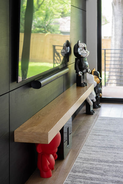 A side shot of a mantle beam and black wall finished with Rubio Monocoat products.