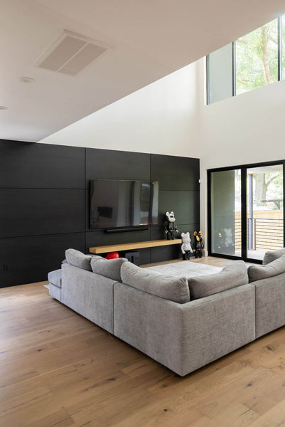 An angled shot of a modern chippendale living room which features a black wood wall finished in rubio monocoat products.