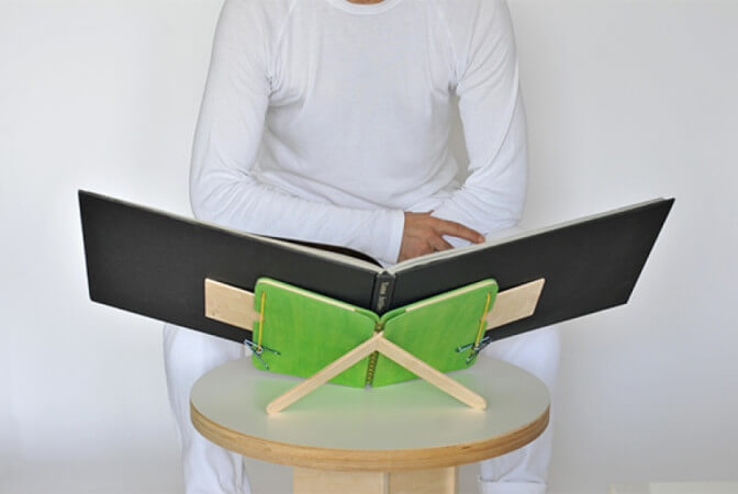Man sitting using a book saddle.