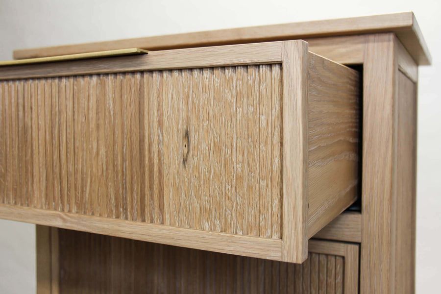 A slightly lower angle of an open white oak dresser drawer with a brass pull from Restoration Hardware finished with Rubio Monocoat Oil Plus 2C hardwax oil.