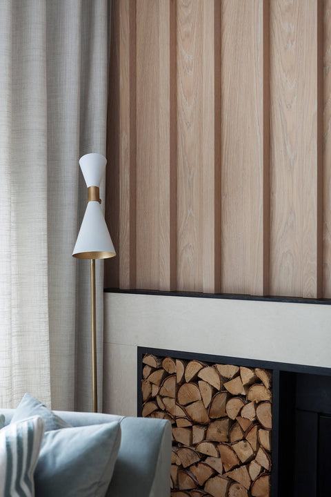 Close-up of white oak slat paneling in Rubio Monocoat Oil Plus 2C Natural, showing natural grain and tone beside a brass and white cone floor lamp.