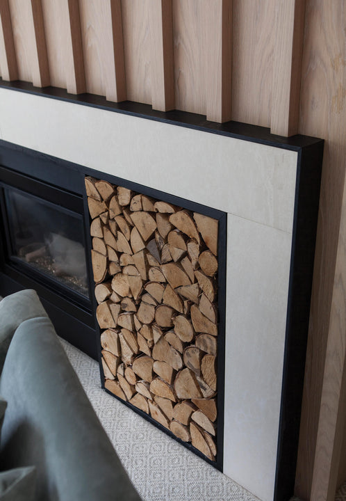 Detail shot of a stone fireplace surround beneath white oak fluted paneling finished with Rubio Monocoat Oil Plus 2C Natural.