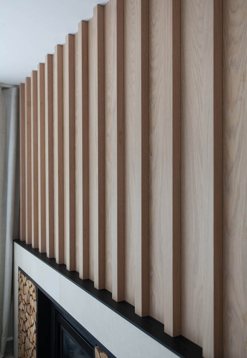 Angled detail of vertical white oak wall slats finished in Rubio Monocoat Oil Plus 2C Natural, highlighting the wood grain and shadow reveals between boards.