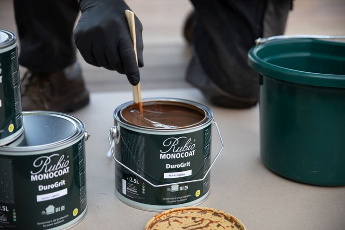 Stirring DuroGrit in the pot prior to applying to a wood deck