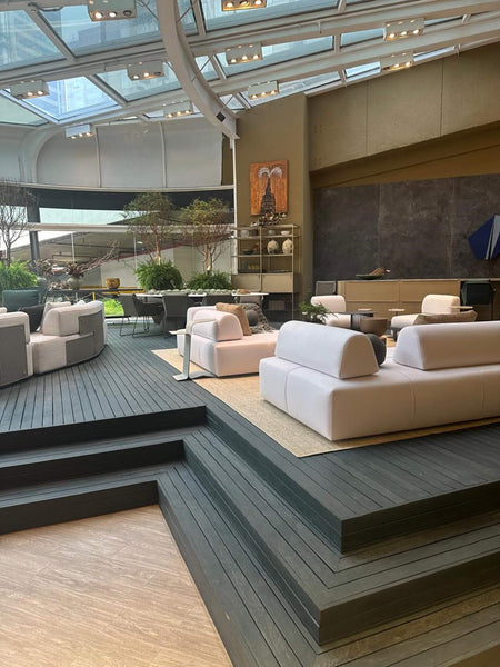 Outdoor furniture is showcased on a wooden deck in a home furnishing store. The decking was colored and protected with Rubio Monocoat DuroGrit exterior wood stain and finish in one.