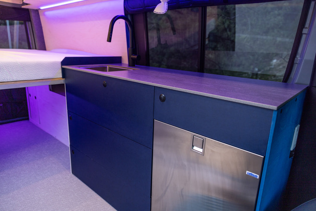 Blue cabinetry in a camper van with an end panel finished with a custom Oil Plus 2C color.