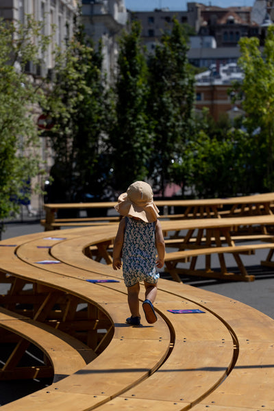 A child walking on top of a unique, winding outdoor table made from spruce and finished with DuroGrit exterior wood stain and finish in one.