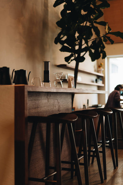 A dark colored oak counter height table with three stools.