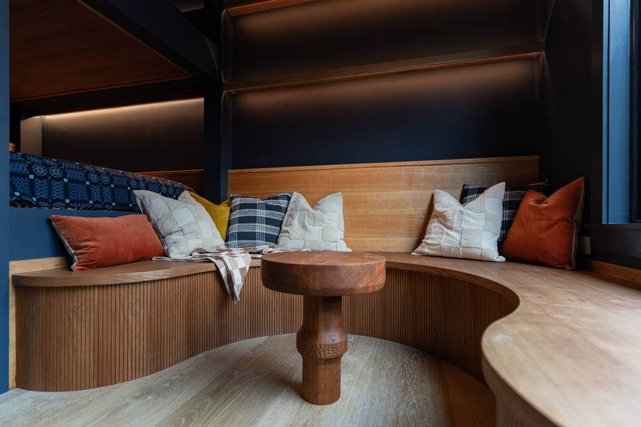 Wood seating area off a set of built-in bunk beds made from cherry. 