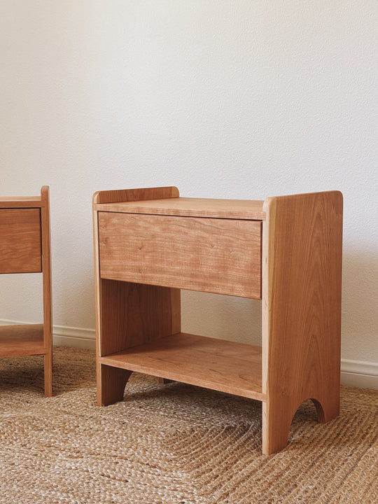 A solid cherry nightstand with curved corners and arched feet finished with Rubio Monocoat Oil Plus 2C hardwax oil wood stain and finish for interior wood projects.