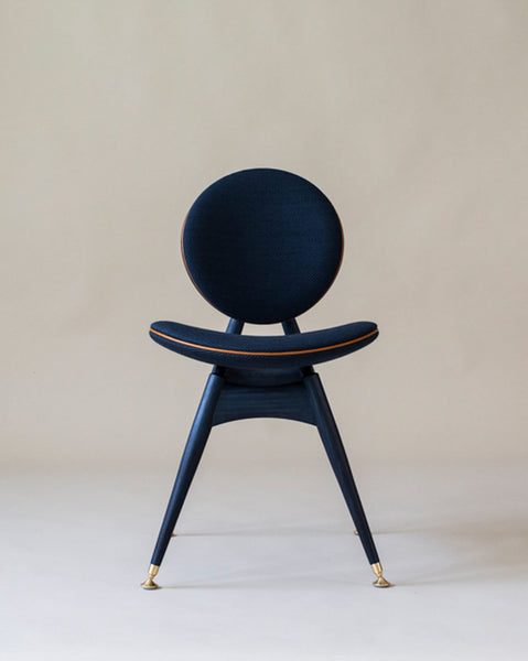 A modern dining chair featuring a circle back and seat made from ash wood. 