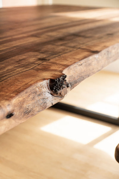 A knot in a walnut dining table finished with Rubio Monocoat hardwax oil wood finish.