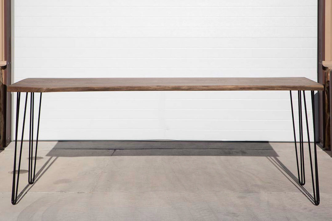 A white oak slab dining table featuring hair-pin legs finished with Rubio Monocoat Oil Plus 2C hardwax oil wood stain and finish in one.