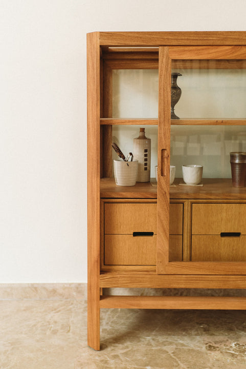 A straight-on image of half of a display cabinet made from Angsana and finished using Rubio Monocoat Oil Plus 2C hardwax oil wood finish. The door on the cabinet is slightly ajar.