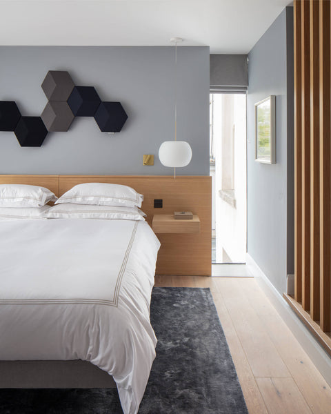 A headboard nightstand combination piece and wood slat room divider crafted from oak wood finished with Rubio Monocoat Oil Plus 2C hardwax oil wood stain and finish.