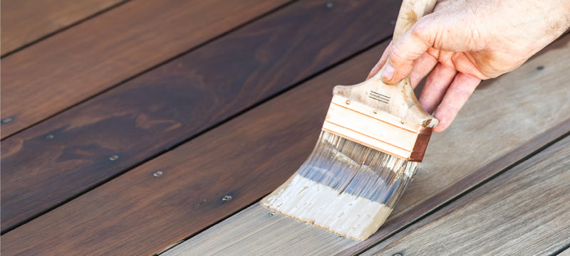 Someone using Rubio Monocoat's exterior wood finish product, DuroGrit, and applying it as wood stain protection for decking.