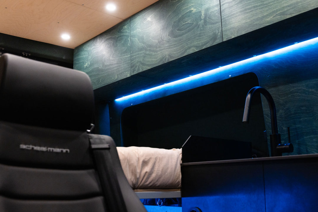 Wood cabinetry in a sprinter van with under cabinet LED lighting.