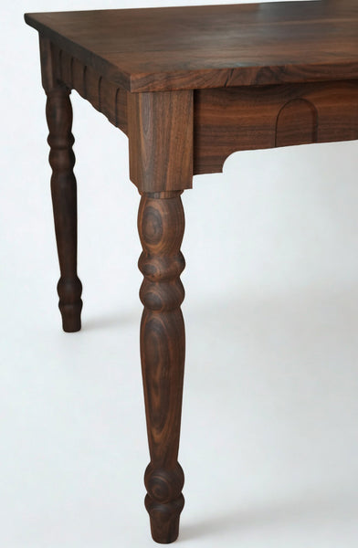 Turned leg and arched apron detail on a walnut dining table finished with Rubio Monocoat Oil Plus 2C "Pure".