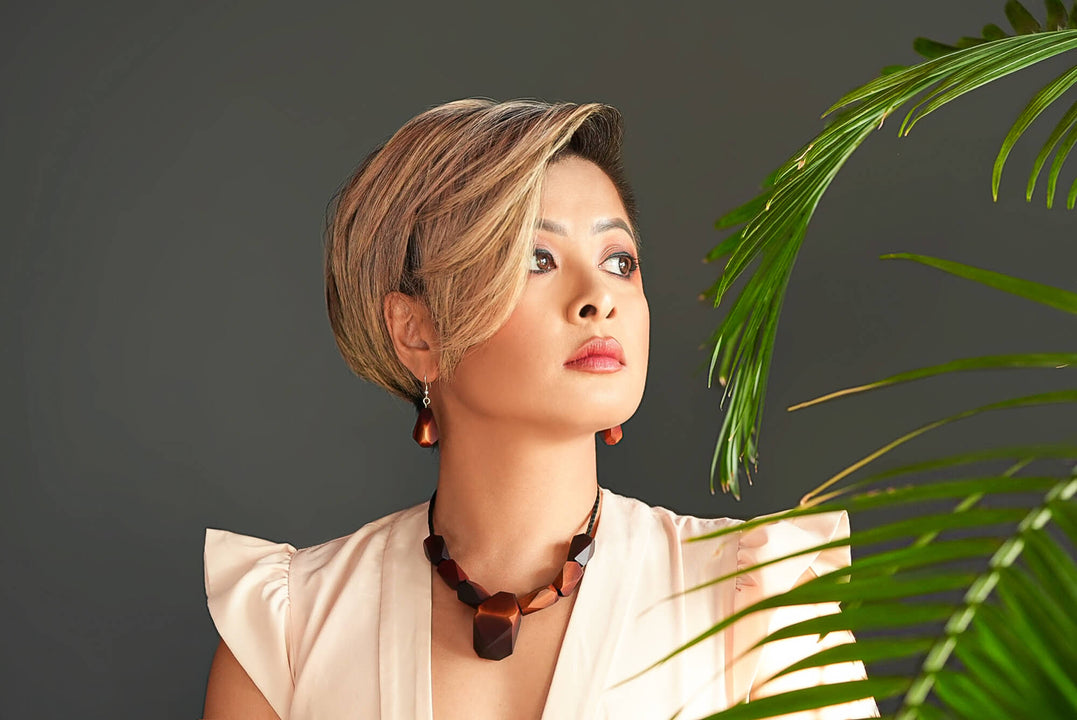 Woman wearing faceted wood necklace and earrings finished with Rubio Monocoat Oil Plus 2C Pure and SheenPlus