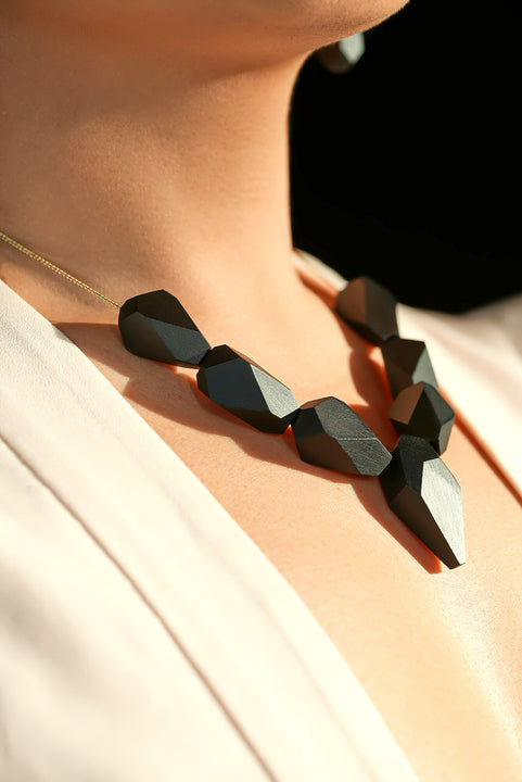 Close-up of geometric faceted wood necklace beads finished with Rubio Monocoat Oil Plus 2C Pure and SheenPlus