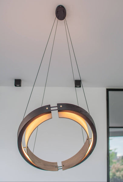 A handmade round wood chandelier made from oak wood and finished with a variety of Rubio Monocoat products.