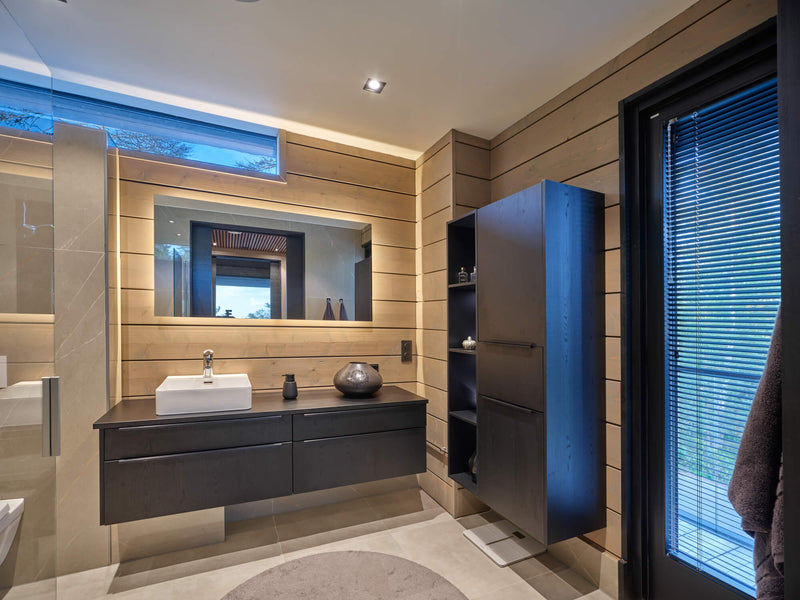 Bathroom with a floating vanity and cabinetry finished. The bathroom also features spruce wall paneling. 