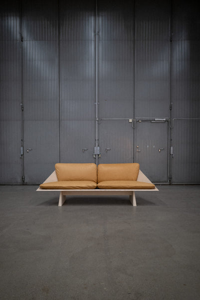 Leather cushions are placed on an ash sofa crafted from ash wood and finished using Rubio Monocoat Oil Plus 2C hardwax oil wood stain and finish.