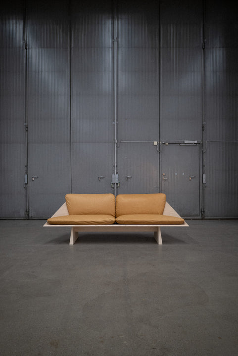 Leather cushions are placed on an ash sofa crafted from ash wood and finished using Rubio Monocoat Oil Plus 2C hardwax oil wood stain and finish.