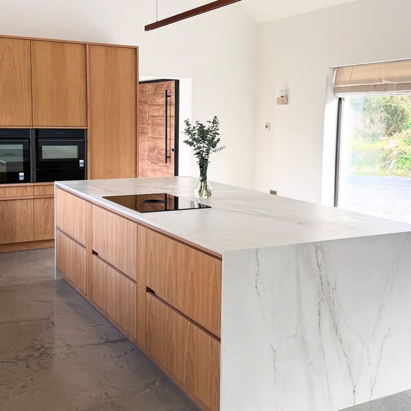 An island with a waterfall edge counter top and cabinetry finished with Rubio Monocoat Oil Plus 2C "Smoke 5%".