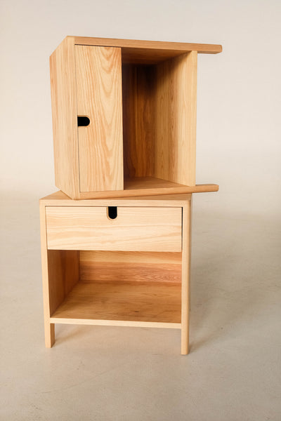 Two ash side tables are displayed with one on top of another. 