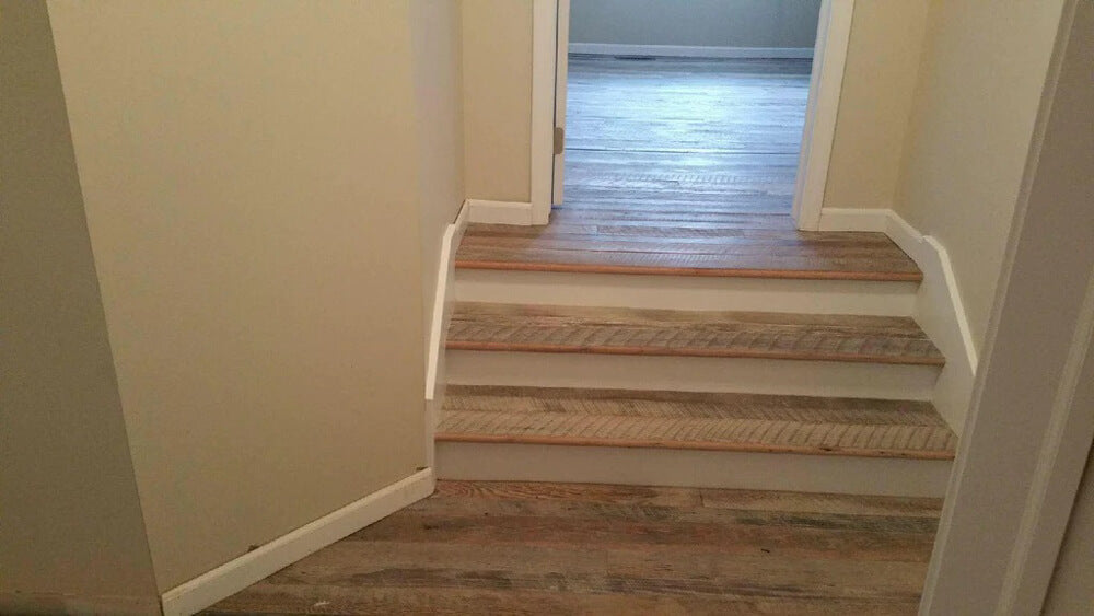 Several barnwood steps in a hallway transitioning up to a split level area.