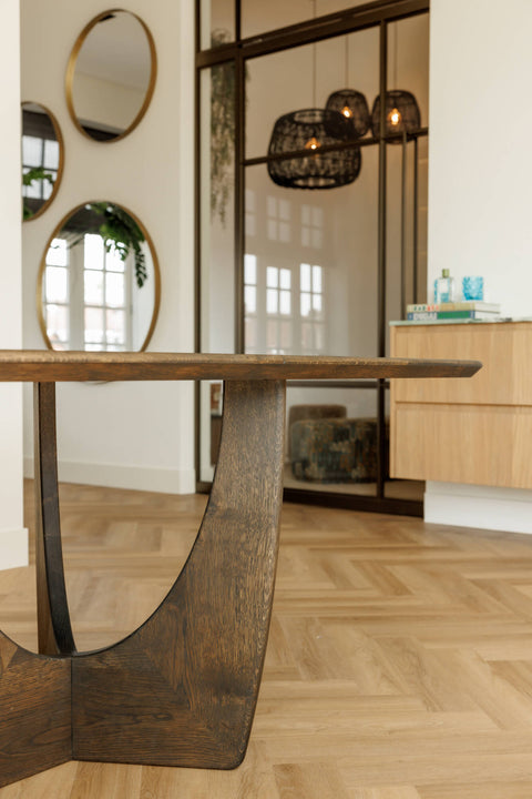 Detail shot of an oak dining table with a unique base finished with a single layer wood stain and sealer.