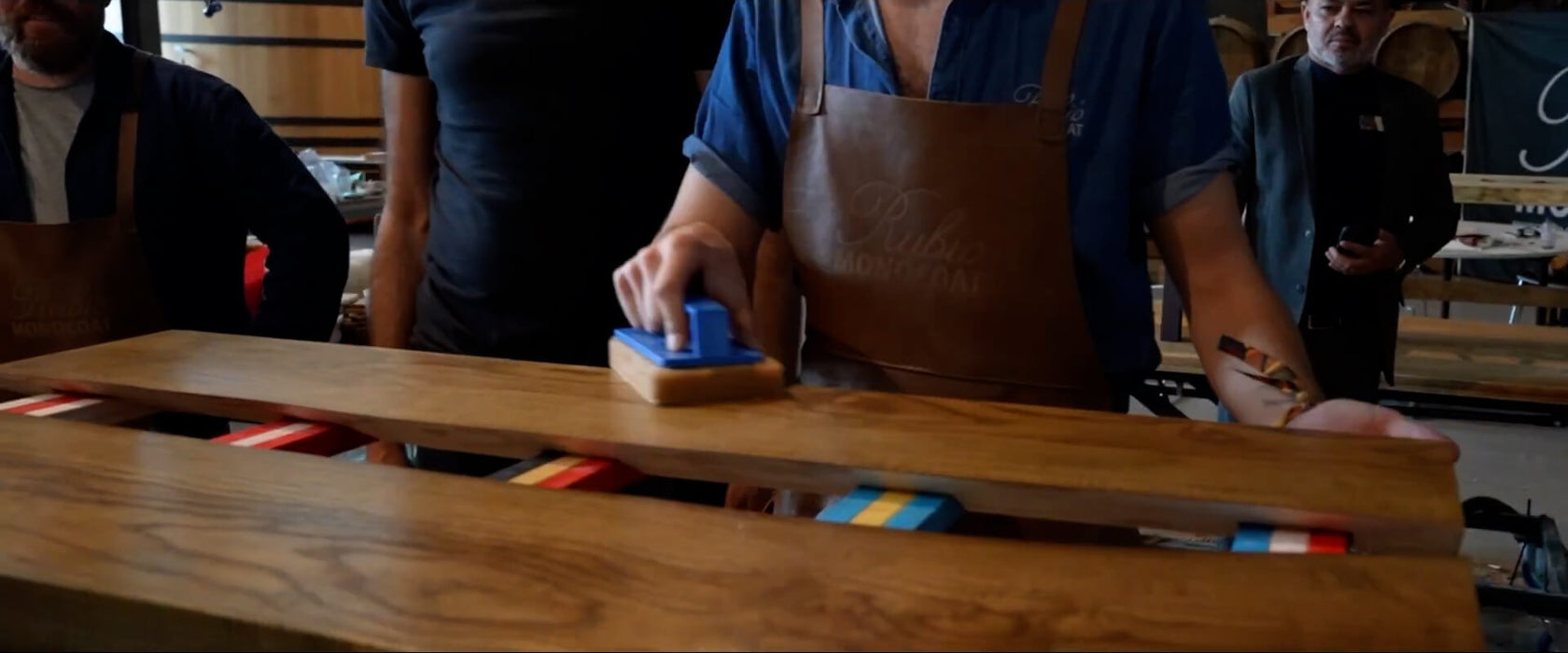 Makers at the PhilanthroMake event applying Rubio Monocoat to a wood table