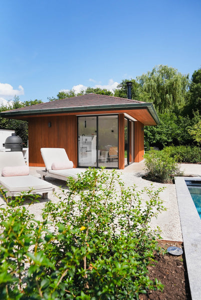 A beautiful, modern poolhouse with vertical Thermo Ayous siding finished with Rubio Monocoat DuroGrit Foxy Brown.