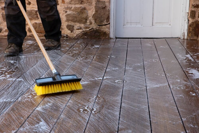 Contractor cleaning a deck surface using Exterior Wood Cleaner before finishing it with deck stain.