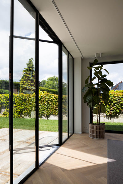 An home's entryway with a wall of glass doors entering to a hardwood floor finished with Rubio Monocoat Oil Plus 2C.