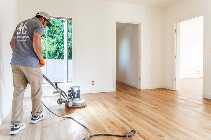 Professional hardwood floor contractor applying Rubio Monocoat to a living room