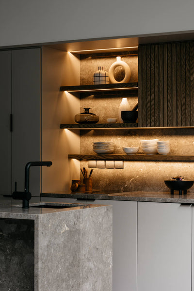 Modern wood kitchen cabinets, floating shelves, undercabinet lighting and a stone, waterfall island